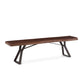 A hand-crafted bench with a live edge on a thick Acacia slab on top and sleek, hand-forged iron bases.