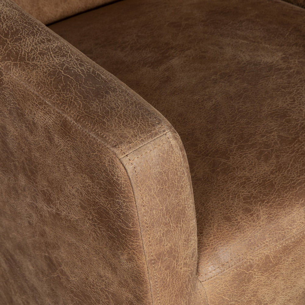 Close-up of a brown leather sofa with visible texture and stitching.
