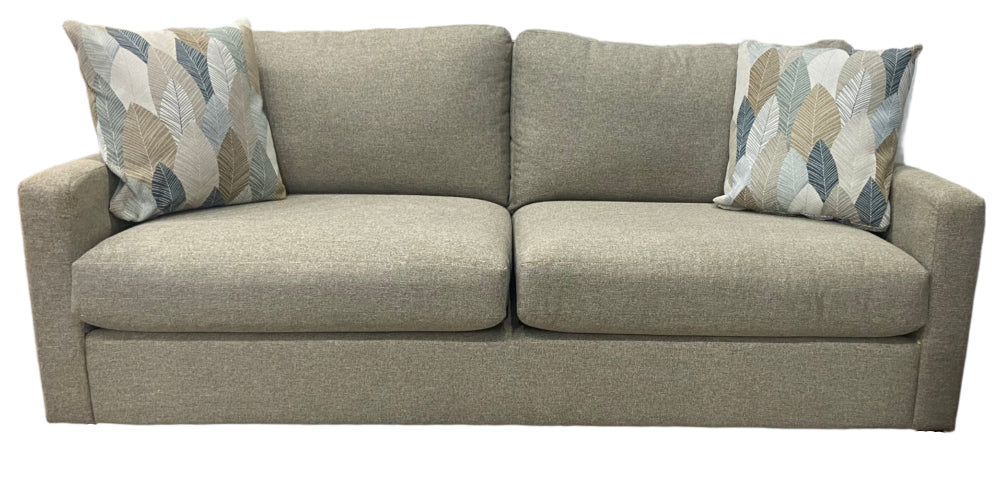 Beige sofa with patterned cushions on a white background