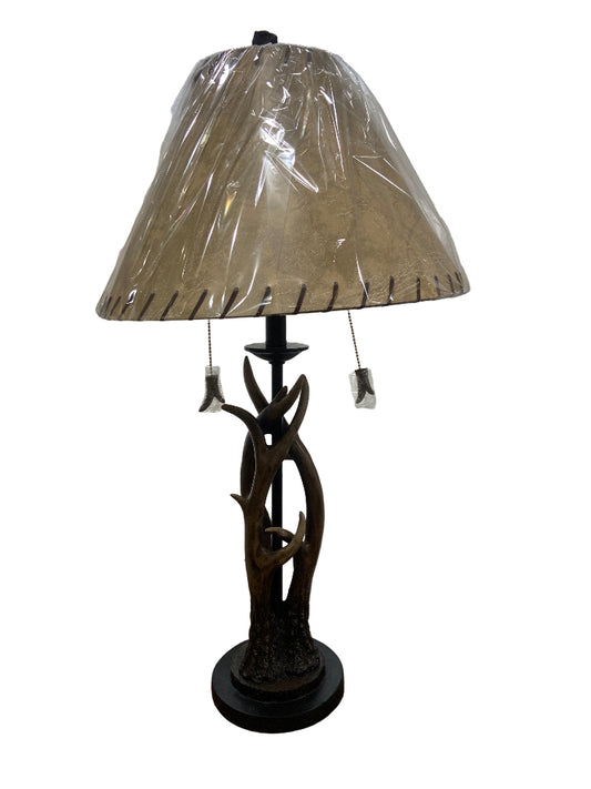 Table lamp with decorative base and beige lampshade on a white background