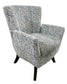 A blue and white patterned accent chair with a bowed backrest and flared legs, set against a white background.
