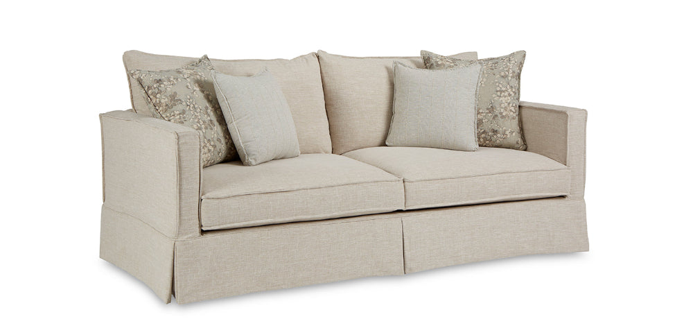 Beige sofa with patterned cushions on a white background