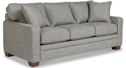 A contemporary sofa with clean lines, featuring track arms, decorative wood legs, and generously sized cushions.