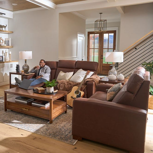 Living room with brown sofa, gray armchair, and wooden coffee table.