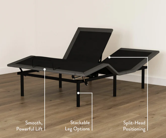 Black adjustable bed with features highlighted on a wooden floor.