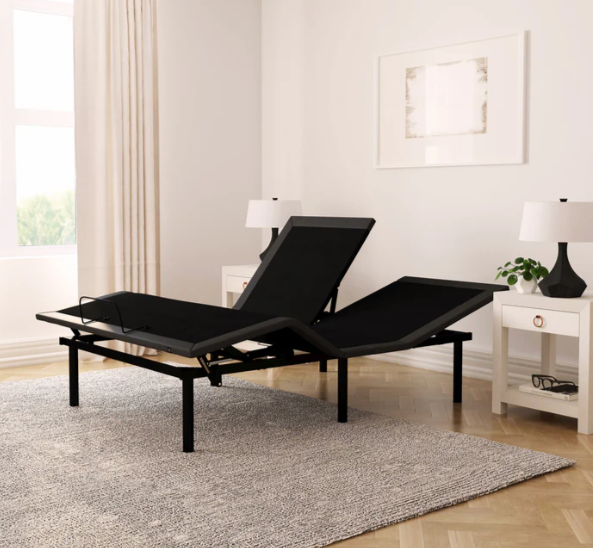 Black adjustable bed in a room with white walls and a rug.