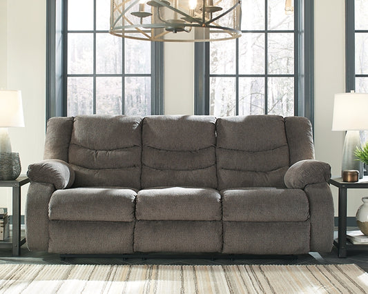 Gray sofa in a living room with large windows and decorative elements.