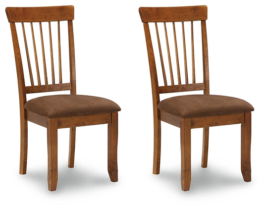 Two wooden chairs with brown cushioned seats on a white background