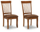 Two wooden chairs with brown cushioned seats on a white background
