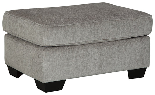 Gray upholstered ottoman with black legs on a white background