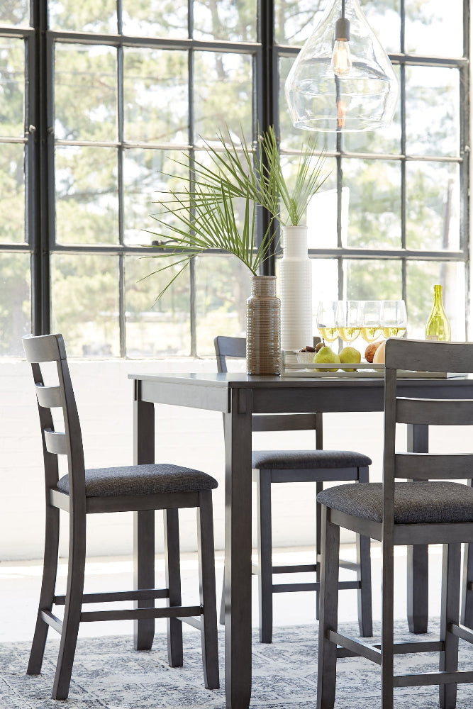 Dining room with a table and chairs near large windows.