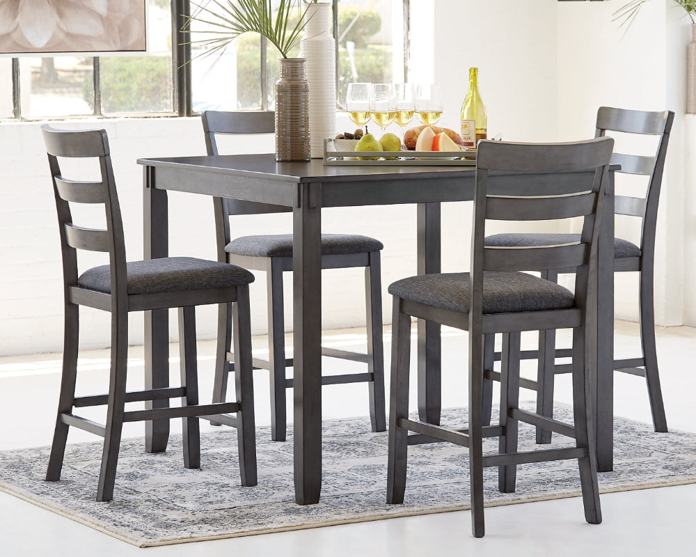 Dining room with a gray dining table and four matching chairs on a rug.