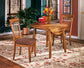 Wooden dining table with chairs on a floral rug in a home setting