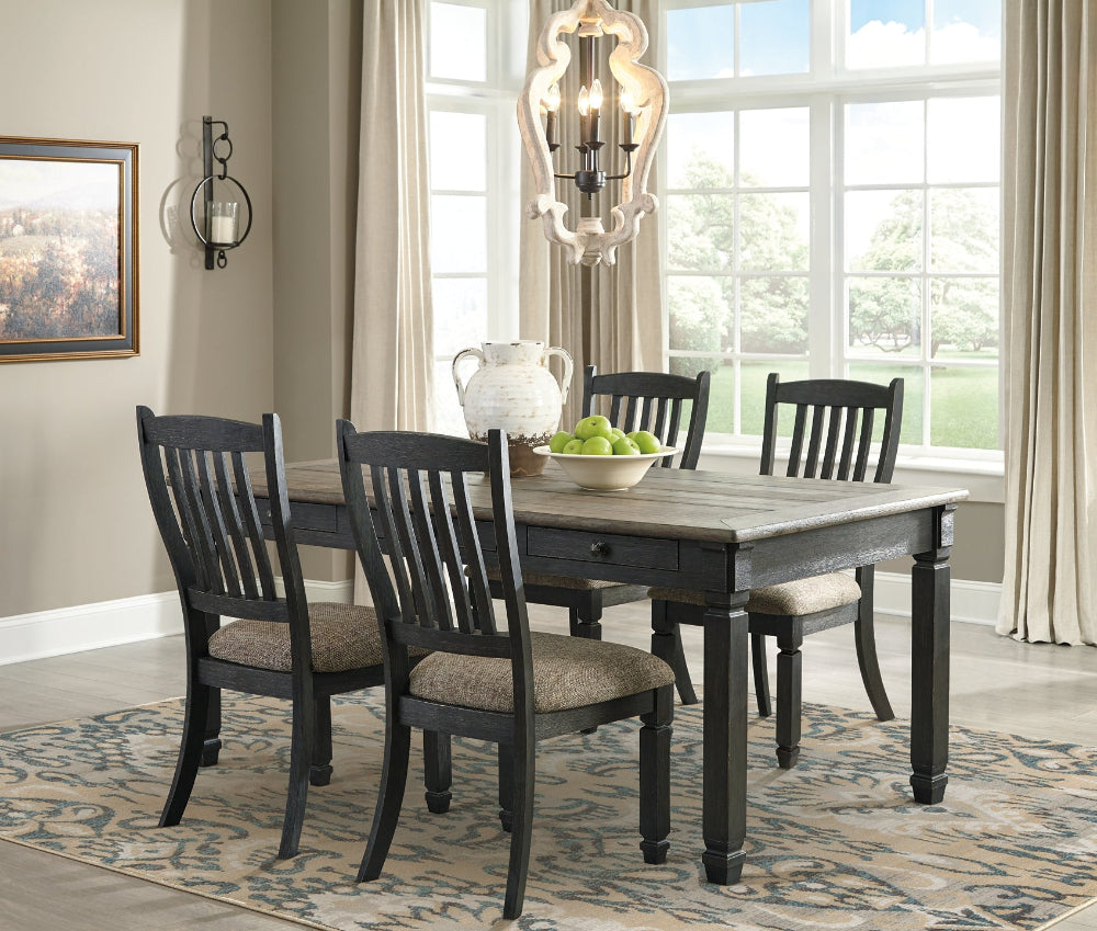 Dining room with a wooden table and chairs near a large window.