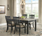 Dining room with a wooden table and chairs near a large window.