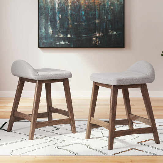 2 gray upholstered stools on a white rug with an abstract painting on the wall