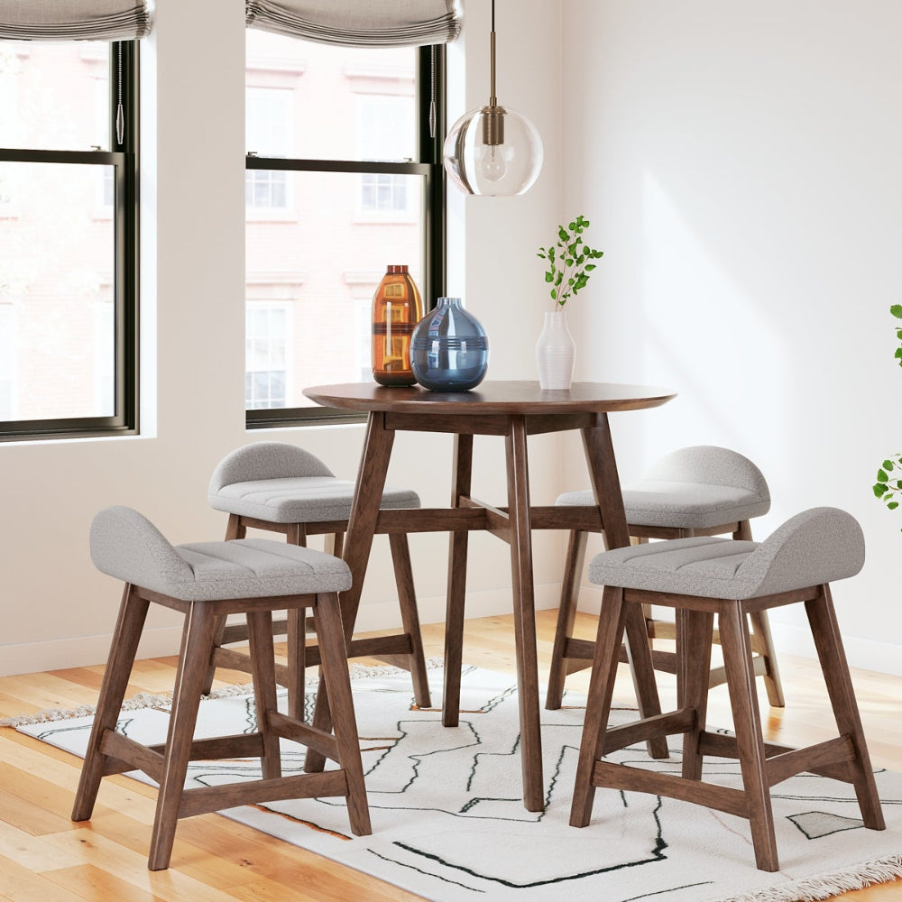 4 gray upholstered stools around a brown round counter height table