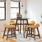4 yellow upholstered stools around a brown round counter height table