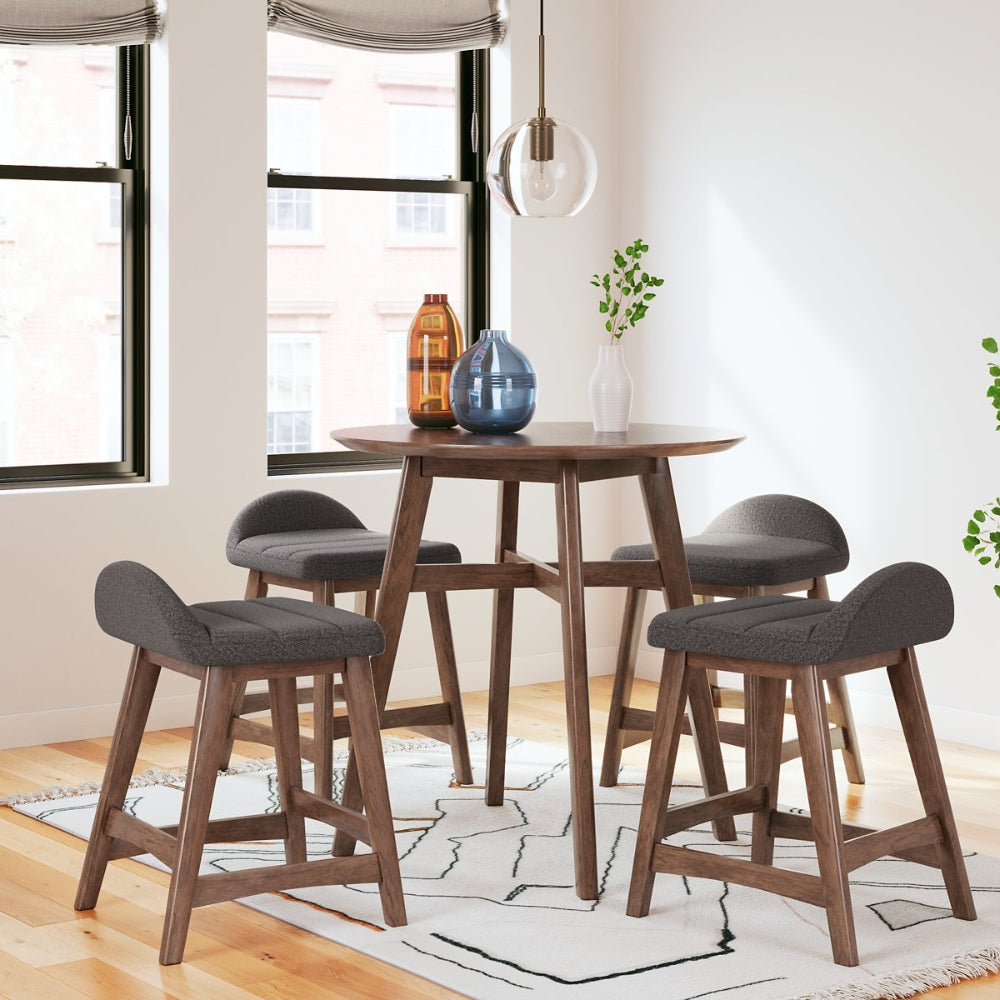 4 dark gray upholstered stools around a brown round counter height table