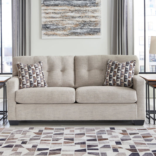 Beige sofa in a living room with patterned rug and decor