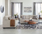 Modern living room with beige sofa and loveseat, a coffee table, and decorative elements.