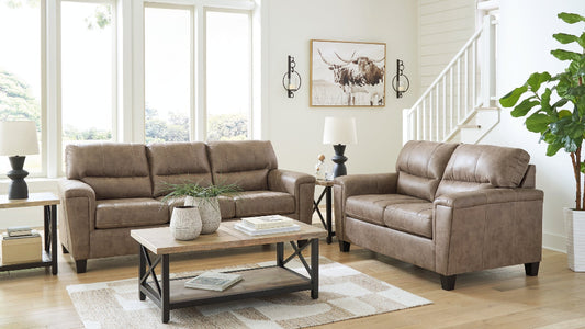 Brown leather sofa and loveseat in a living room with a coffee table and decor items.