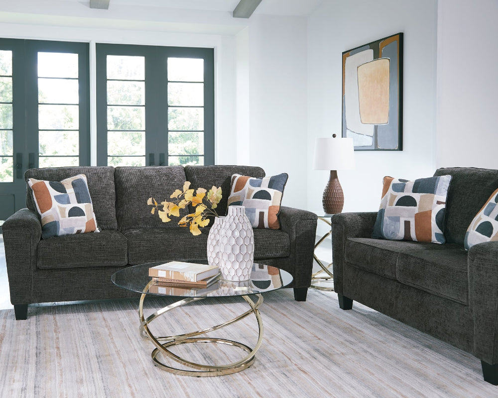 Living room with gray sofa and loveseat, a coffee table, and decorative items.
