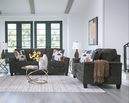 Living room with gray sofa and loveseat, colorful pillows, and a coffee table.