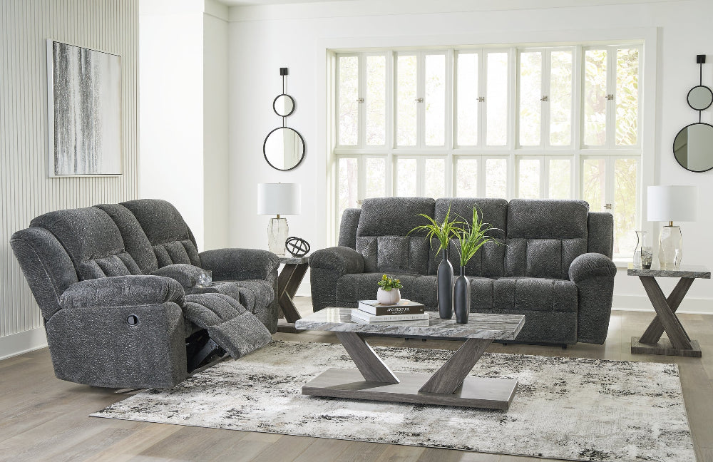 Gray reclining sofa set in a modern living room with a coffee table and decor.