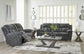 Gray reclining sofa set in a modern living room with a coffee table and decor.