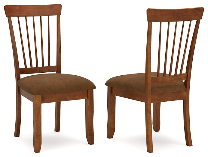 Two wooden chairs with brown cushioned seats on a white background