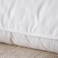 Close-up of a white quilted mattress pad on a textured surface.