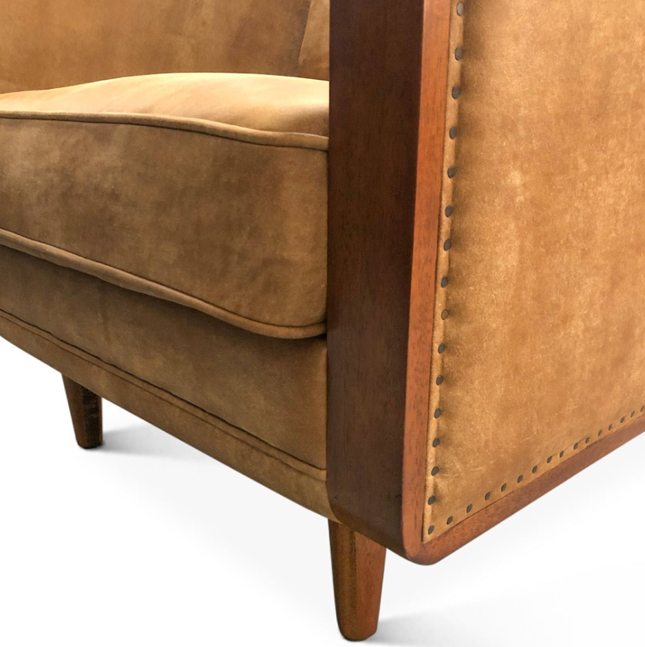 Brown leather armchair with wooden frame and nailhead trim on a white background