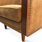 Brown leather armchair with wooden frame and nailhead trim on a white background